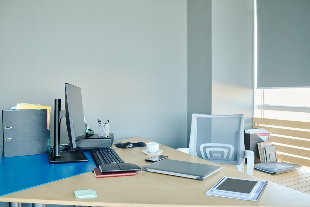Monitor arm setup on an office desk with adequate clamp space and stable desktop support for ergonomic screen positioning